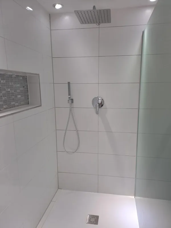 Walk-in-Dusche mit weißen Fliesen und Wandnische